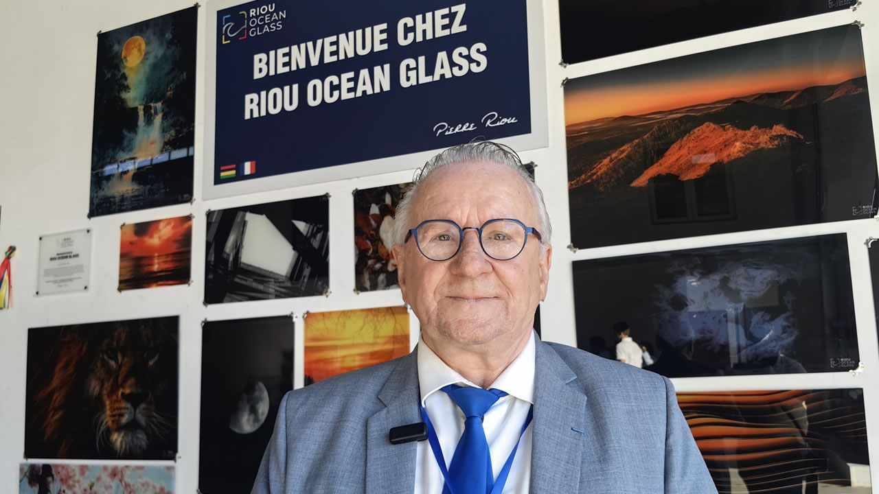 Le président du groupe, Pierre Riou, pose fièrement devant une sélection de verres spécialement imprimés aux motifs variés.